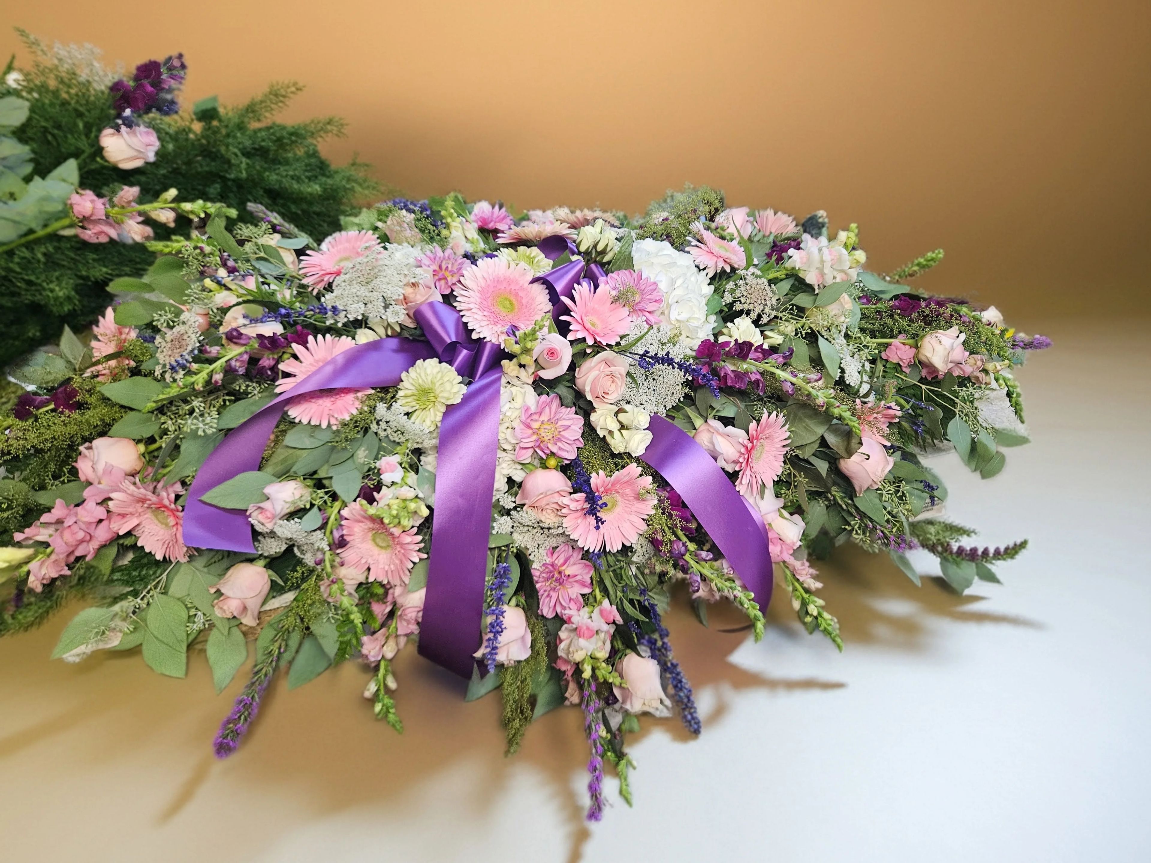 Pink and purple casket spray